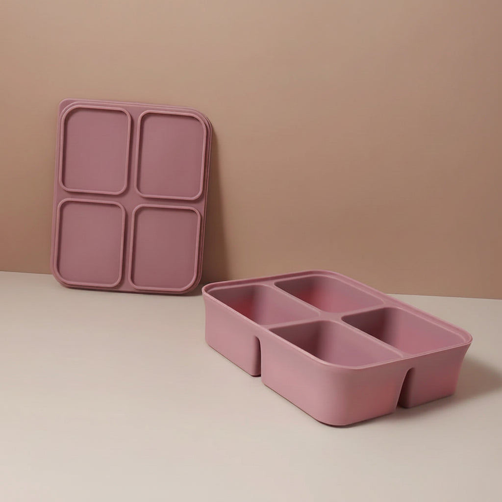 Pink silicone tray with compartments on a beige surface and background