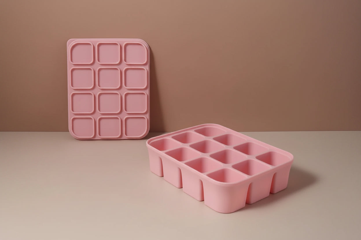 Pink silicone ice cube tray with dimensions on a beige background