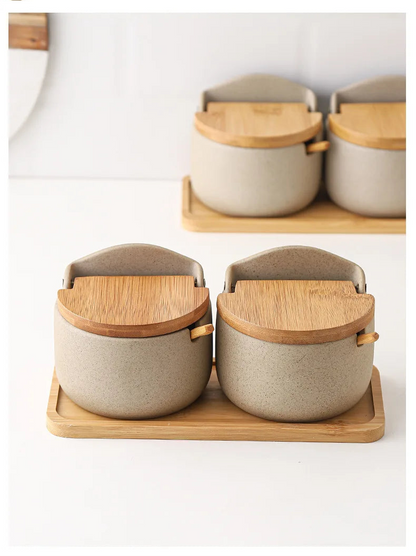 Set of ceramic containers with wooden lids on a wooden tray